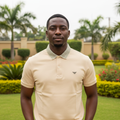 Nigerian male model wearing cream polo shirt with geometric collar in garden setting