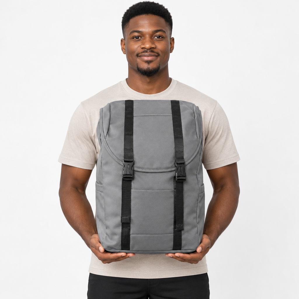 Adult model holding a grey twin-buckle backpack front-facing