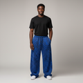 Model wearing blue leopard print baggy joggers with a black t-shirt