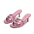 Pair of metallic pink buckle-detail heeled mules on pure white background
