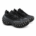 Pair of black chunky sneakers with silver-tone studded soles on white