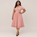 Black Nigerian model wearing a dusty rose pleated midi gown with a double-breasted bodice and ruffle hem