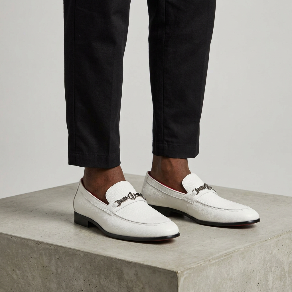 Men's white buckle-detail slip-on loafers worn with relaxed-fit trousers