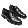 Pair of black medallion cap-toe brogues with black lug soles on a white background