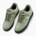 Pair of sage suede rope-lace sneakers with black soles on white background
