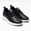 Pair of black textured slip-on shoes with white soles on white
