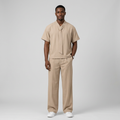 Nigerian male model wearing beige tie-neck shirt and wide-leg trouser set