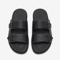 Pair of black pebbled double-strap slides on white