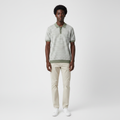 Man wearing the sage green striped knit polo