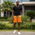 Nigerian male model wearing orange athletic shorts outdoors