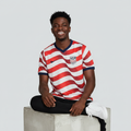 Nigerian male model wearing white red wave stripe football jersey on concrete plinth