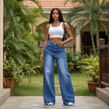 Nigerian female model wearing blue wash wide leg denim jeans with skirt panel overlay in garden setting