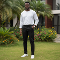 Nigerian male model wearing black chino trousers with white pocket detail in outdoor setting