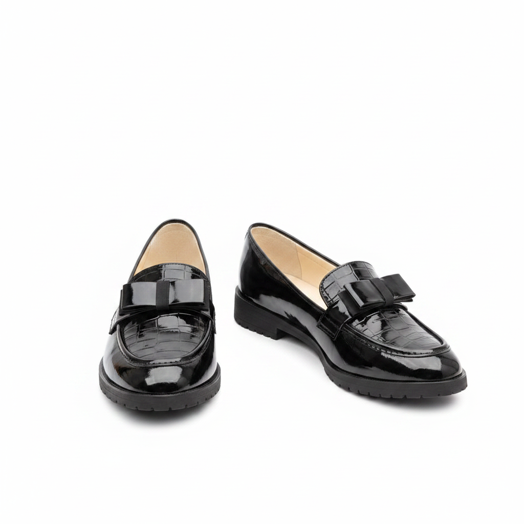 Black croc-embossed patent leather loafer pair with bow detail — ghost mannequin product shot