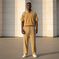 Male model wearing sand khaki open-knit polo and trouser two-piece set