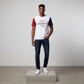 Nigerian male model wearing white colourblock short-sleeved shirt with red and navy sleeves, front view