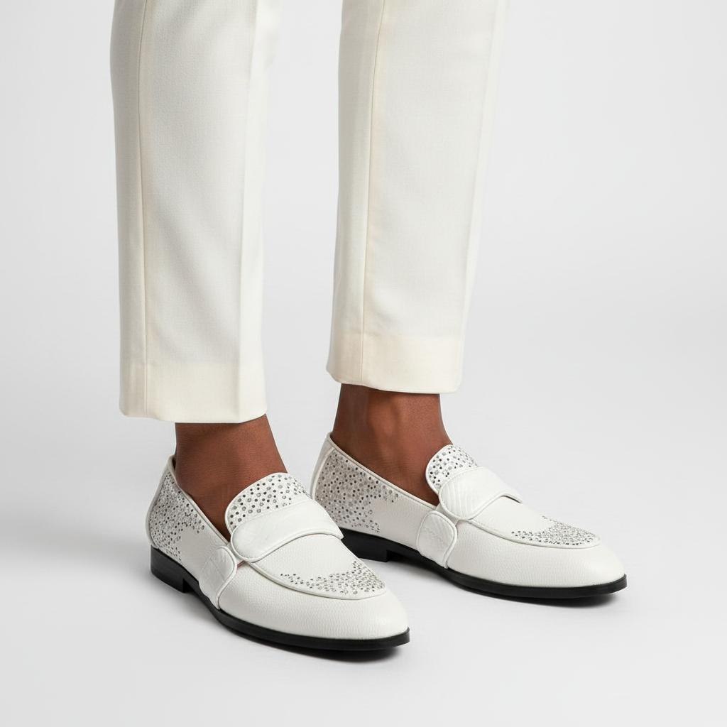 Close-up leg focus showing both men's white rhinestone embellished penny loafers with cream trouser hem