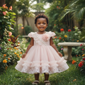 Young Nigerian toddler girl wearing blush pink lace puff sleeve tulle party dress