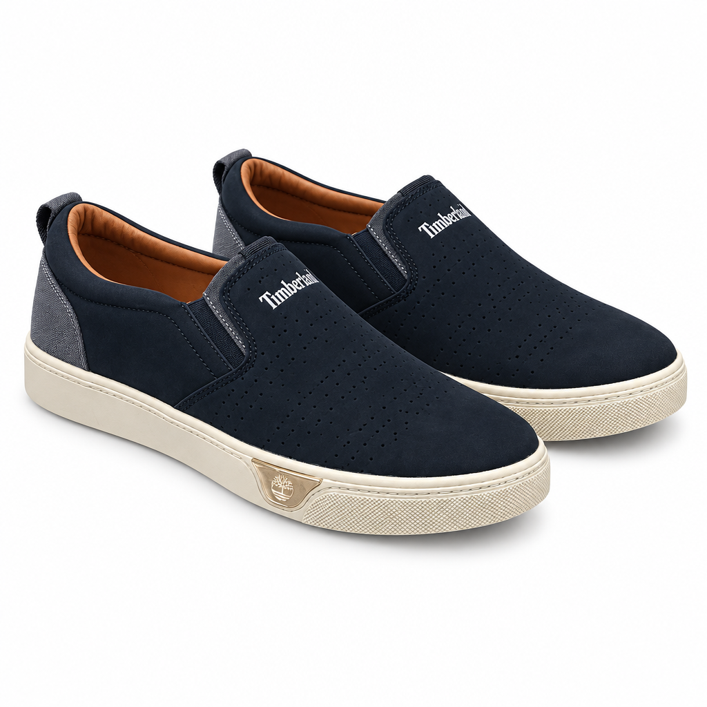 Pair of navy perforated slip-on sneakers with beige soles on white