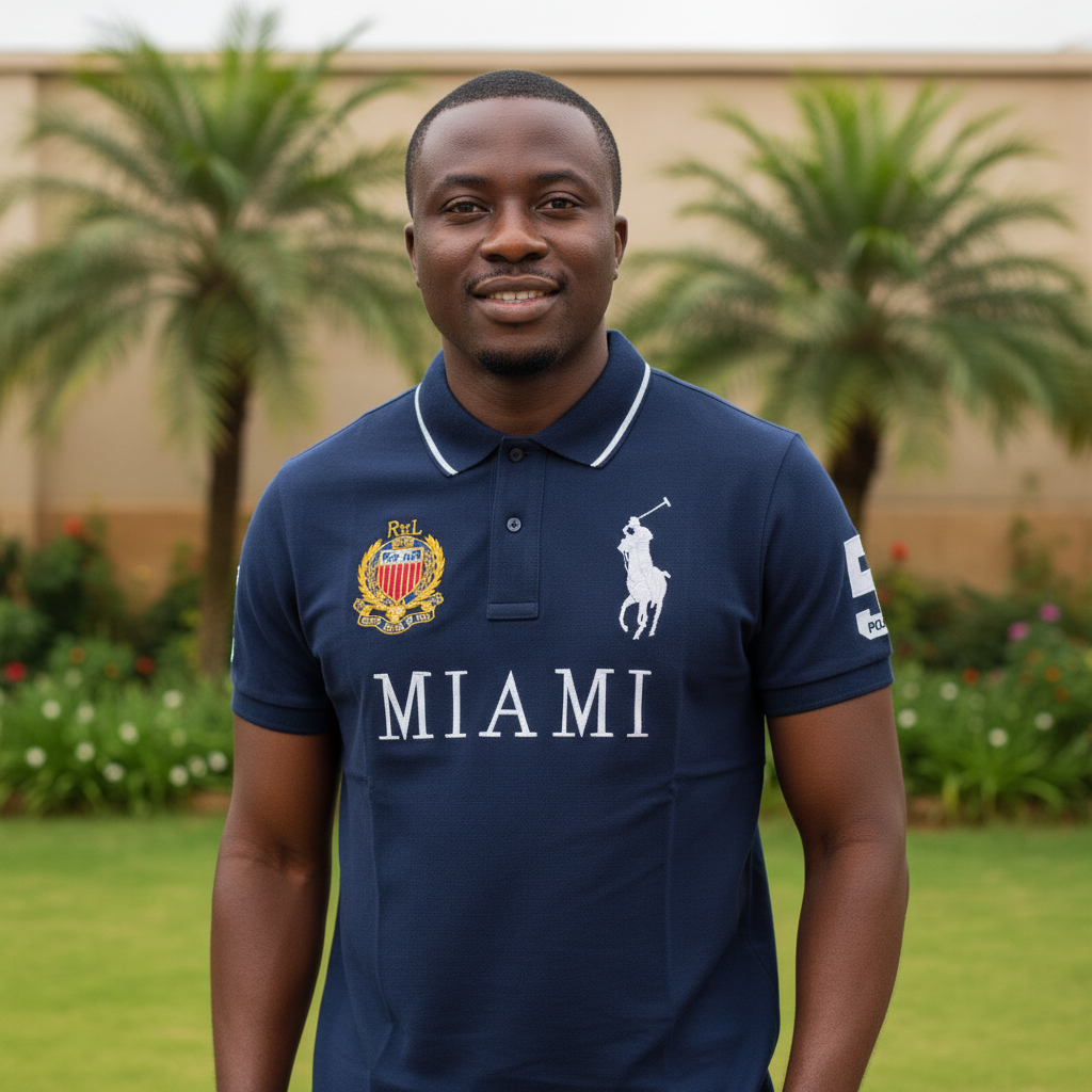 Nigerian male model wearing navy blue graphic polo shirt with crest and city print in garden setting