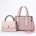 Blush pink textured twin-handle handbag beside smaller pink flap bag with brown handle