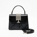 Black top-handle bag with snake-pattern panel, silver-tone crystal-style detail and separate black strap on white