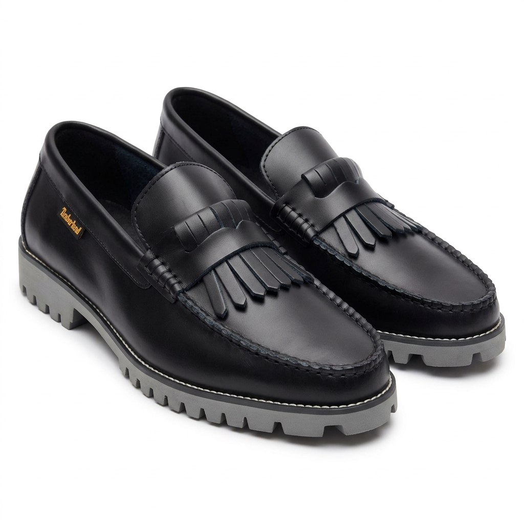 Corrected black fringe loafers showing layered rounded tabs and grey lug soles