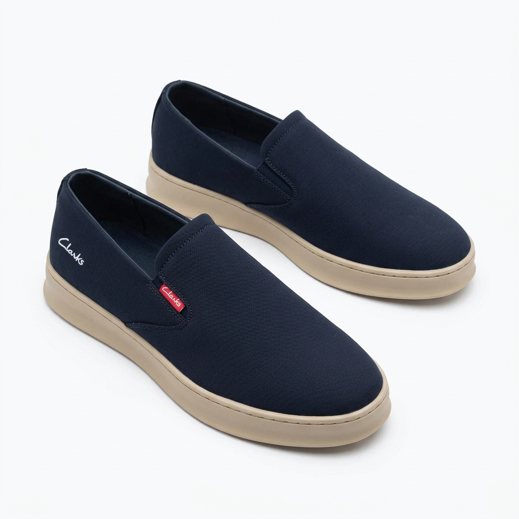 Pair of navy slip-on sneakers with beige soles on white