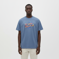 Model wearing the dusty blue painted script graphic t-shirt
