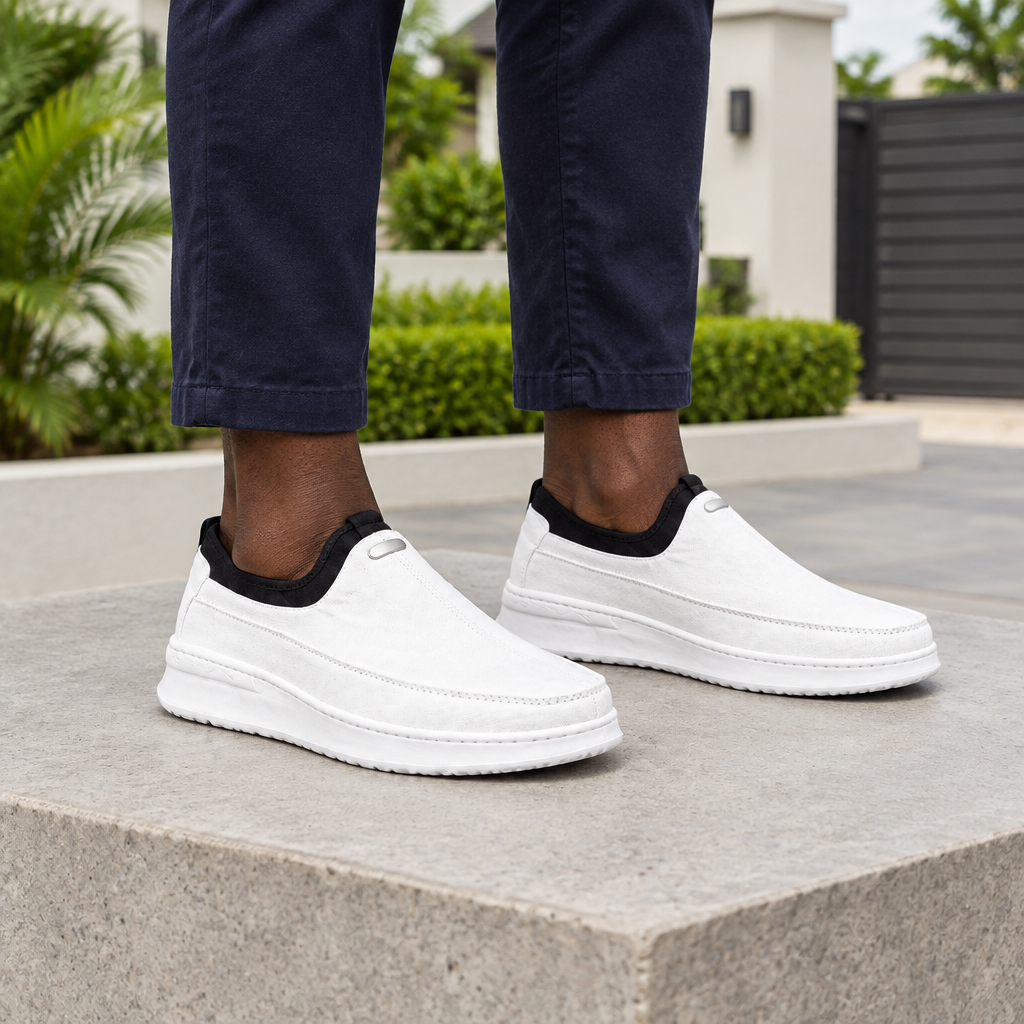 Man wearing white slip-on sneakers with navy trousers