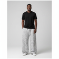 Model wearing light grey leopard print baggy joggers with a black t-shirt