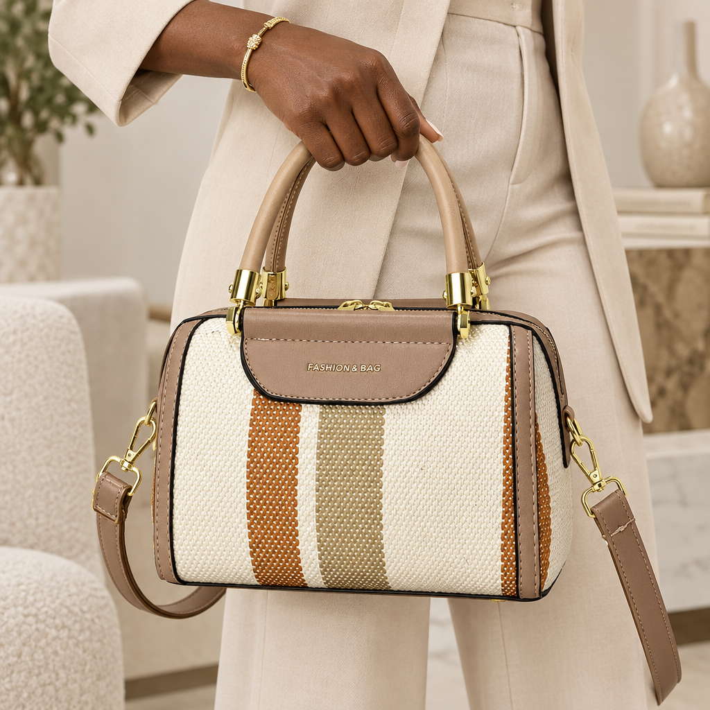 Black Nigerian woman holding sand and ivory striped satchel