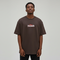 Young Nigerian male wearing dark brown Stay Focused oversized graphic crew neck tee