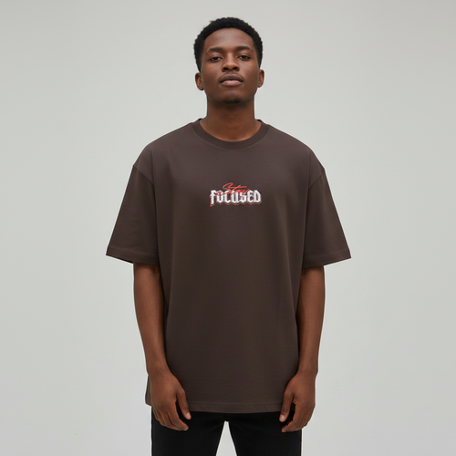 Young Nigerian male wearing dark brown Stay Focused oversized graphic crew neck tee