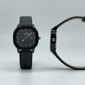 Charcoal-grey dial watch with black case and dark grey leather strap shown from the front and side