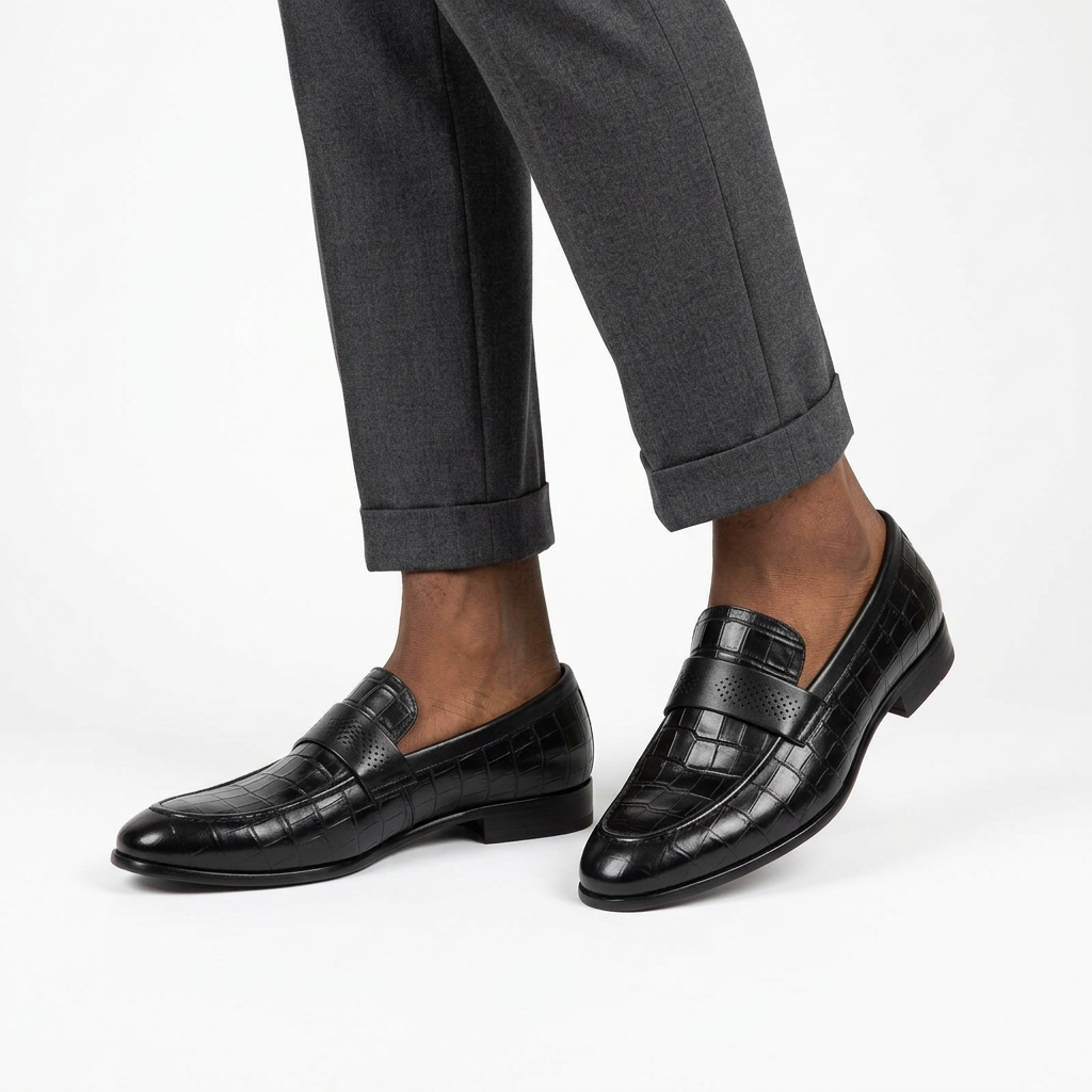 Both black croc-embossed loafers worn with charcoal trousers on white