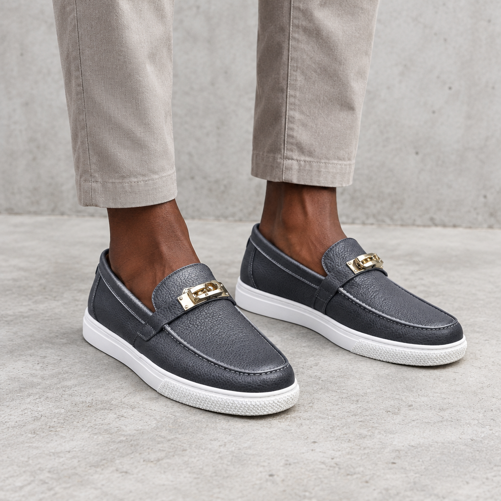 Grey textured loafers with gold-tone detail worn on both feet