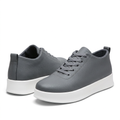 Pair of grey textured lace-up sneakers with white soles on white