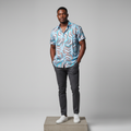 Nigerian male model wearing sky blue geometric print short-sleeved shirt, front view