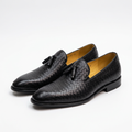 Pair of black basketweave-textured tassel loafers on white