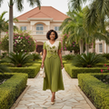 Nigerian female model wearing olive green and cream pleated midi gown in upscale garden setting