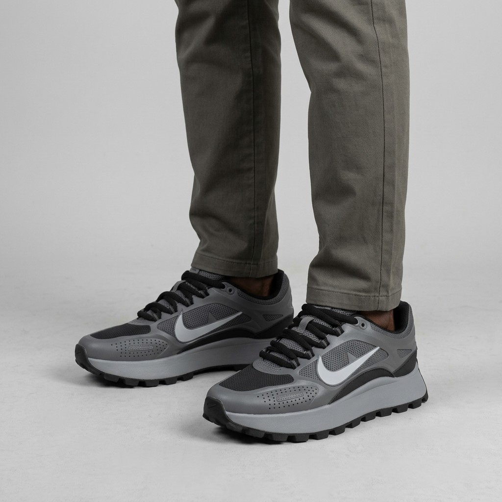 Both feet of Nigerian man wearing charcoal mesh-panel sneakers