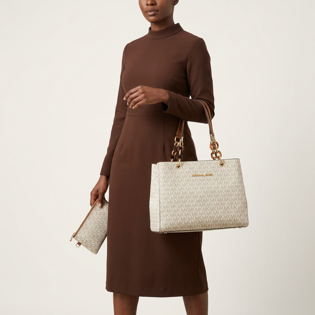 Woman carrying an ivory monogram tote and matching purse against a plain off-white background