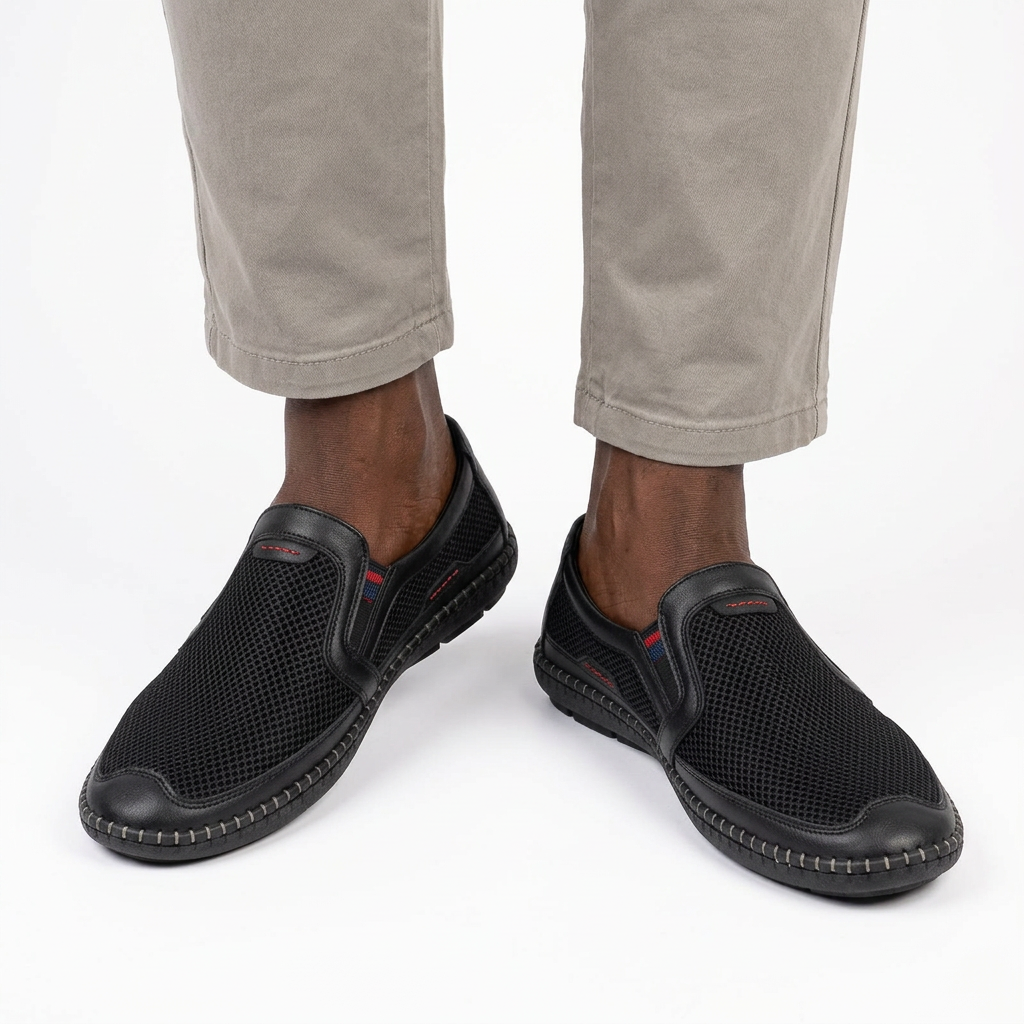 Man wearing black mesh slip-on shoes with both feet visible