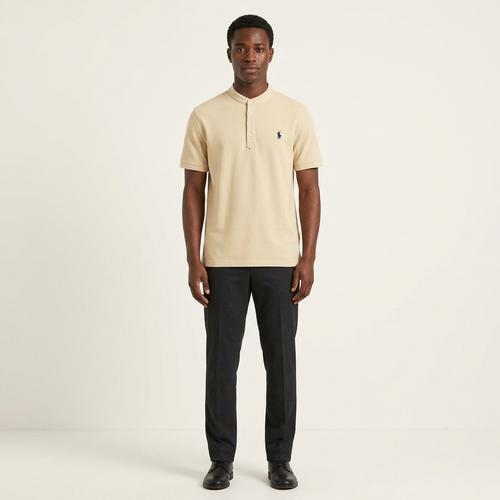 Male model wearing a sand band-collar short-sleeve shirt with dark trousers on a plain off-white background
