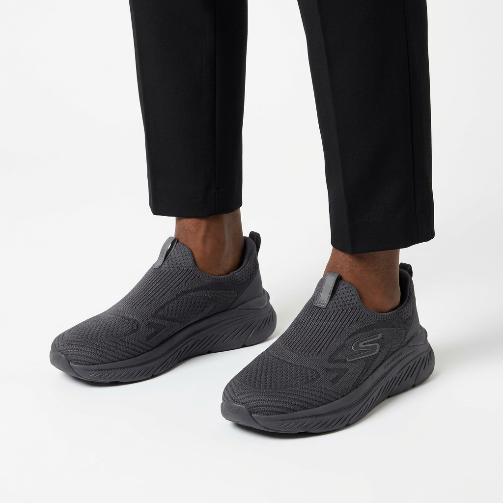 Both charcoal knit slip-on sneakers worn with black trousers on white