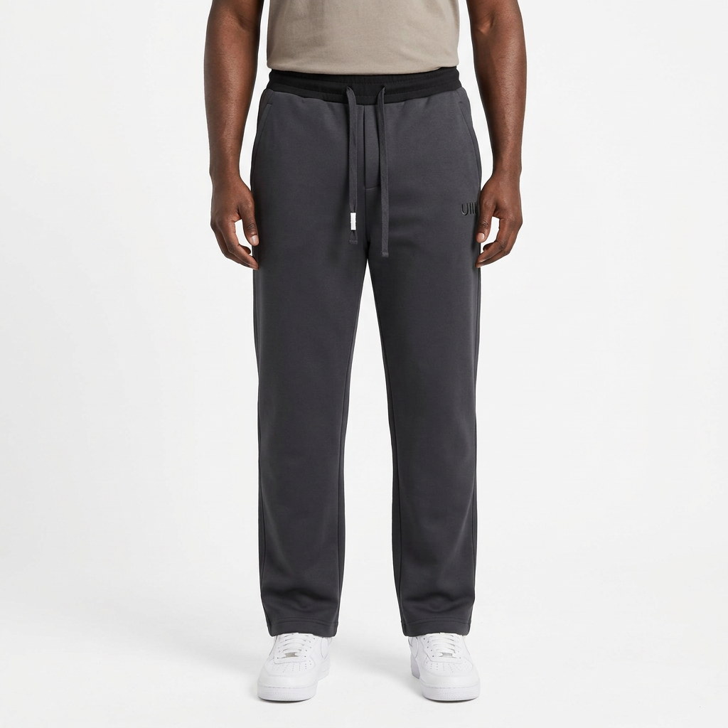 Adult Black model wearing charcoal grey straight-leg joggers with matching dark drawstrings