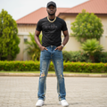 Nigerian male model wearing blue ripped flare jeans in outdoor setting