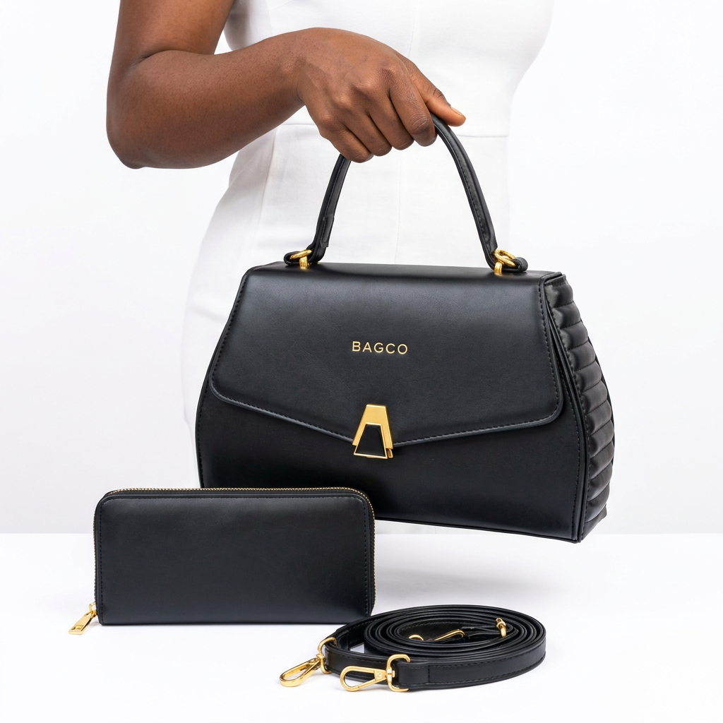 Hand holding a black gold-clasp handbag with matching wallet and strap