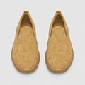 Beige textured slip-on shoes with stitched rounded toes and matching soles
